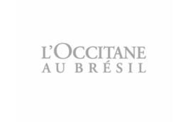 A imagem mostra o logotipo da L'Occitane au Brésil, apresentando o nome da marca em uma fonte cinza simples e elegante sobre um fundo branco.